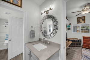 Bathroom featuring vanity, a ceiling fan, and dark wood-style floors