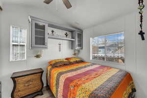 Bedroom with lofted ceiling, ceiling fan, and wood finished floors