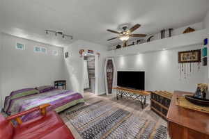 Bedroom featuring light wood-type flooring, a ceiling fan, and rail lighting
