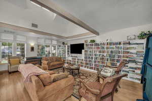 Living area featuring light wood-type flooring and wall of books