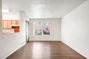 Unfurnished dining area with dark wood-style flooring and baseboards