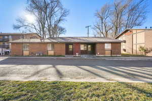 View of front of property with brick siding and roof with shingles