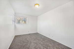 Carpeted spare room with baseboards and a textured ceiling