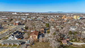 Aerial view of property and surrounding area with nearby urban area and a mountain backdrop