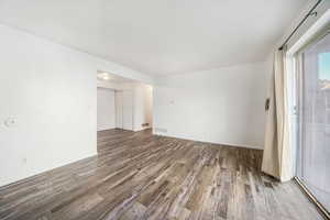Spare room with dark wood-style floors and baseboards
