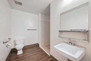 Bathroom featuring walk in shower and dark wood finished floors