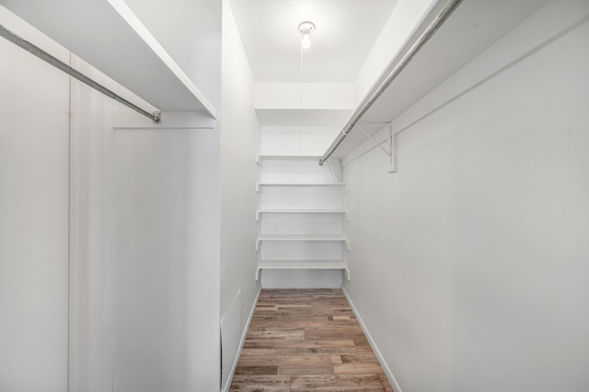 Walk in closet with light wood-style floors