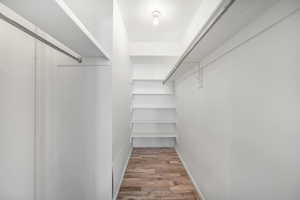 Walk in closet with light wood-style floors