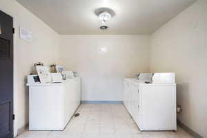 Communal laundry room featuring washing machine and clothes dryer and a heating unit