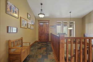 Foyer entrance with tile floors and vaulted ceiling