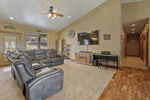 Living area with vaulted ceiling, wood finished floors, recessed lighting, and a ceiling fan