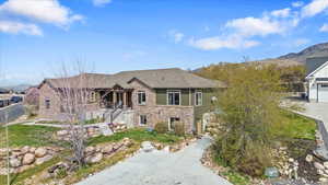 View of front facade featuring stone siding, a mountain view, and porch area