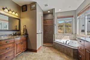 Primary bathroom with double vanities, a garden tub, and a walk in shower