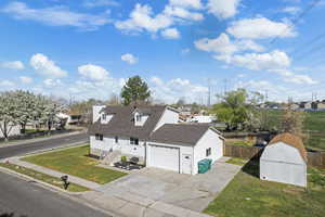 View of front facade with concrete driveway, a residential view, a chimney, and a storage unit