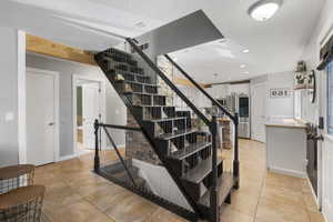 Staircase with tile patterned floors, a textured ceiling, and recessed lighting