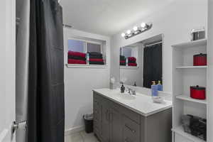 Bathroom featuring vanity, a shower with shower curtain, and light tile patterned floors