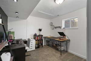 Office featuring dark carpet and a textured ceiling