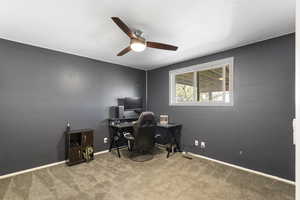 Home office with light colored carpet, a textured ceiling, and a ceiling fan