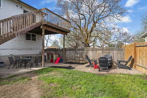 Fenced backyard featuring a patio area, outdoor dining area, and a fire pit