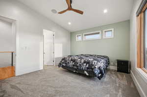 Carpeted bedroom featuring vaulted ceiling, a ceiling fan, and recessed lighting