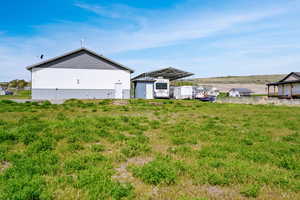 View of yard with an outdoor structure and a covered RV parking