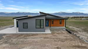 Front view of house with a porch, a view of rural / pastoral area, and a mountain view