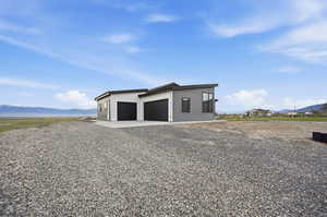 View of three car garage, featuring a mountain view and driveway