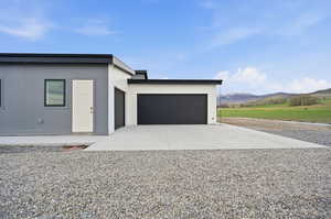 View of North side of property featuring driveway, a mountain view, and 3-car attached garage