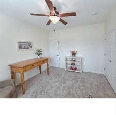 Home office with a ceiling fan and light carpet