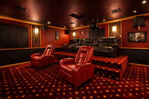 Cinema room with a textured ceiling, recessed lighting, ornamental molding, and carpet
