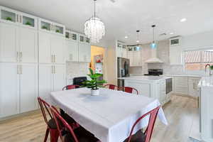 Dining area featuring light wood-type flooring and a chandelier