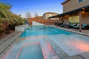 Combined pool / hot tub featuring a patio area, a fenced backyard, and an outdoor living space