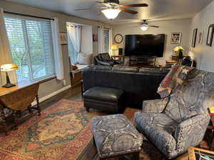 Living area with ceiling fan and wood finished floors