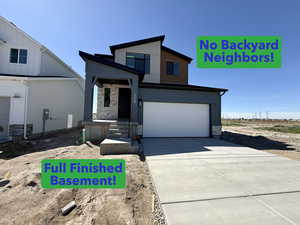 View of front of house with stone siding, concrete driveway, and a garage