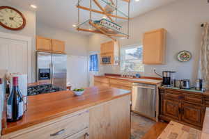 Kitchen with light wood finish cabinetry, stainless steel appliances, butcher block counters, and recessed lighting
