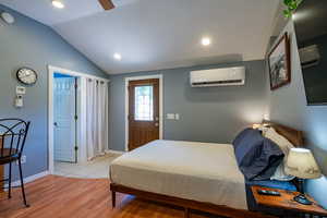 Bedroom with light wood finished floors, vaulted ceiling, a ceiling fan, and recessed lighting