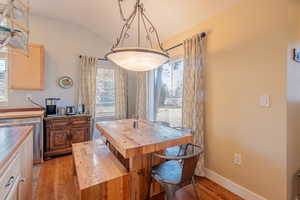 Dining room featuring light wood-style flooring and lofted ceiling