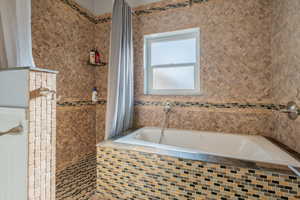 Full bathroom with a tile shower and a garden tub