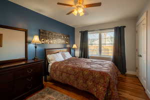 Bedroom featuring dark wood-type flooring, a closet, and a ceiling fan