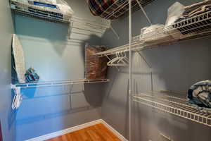 Walk in closet with light wood-style floors