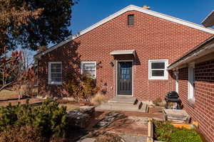 Back of house featuring brick siding and a patio