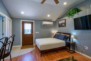 Bedroom featuring light wood finished floors, vaulted ceiling, a ceiling fan, and recessed lighting