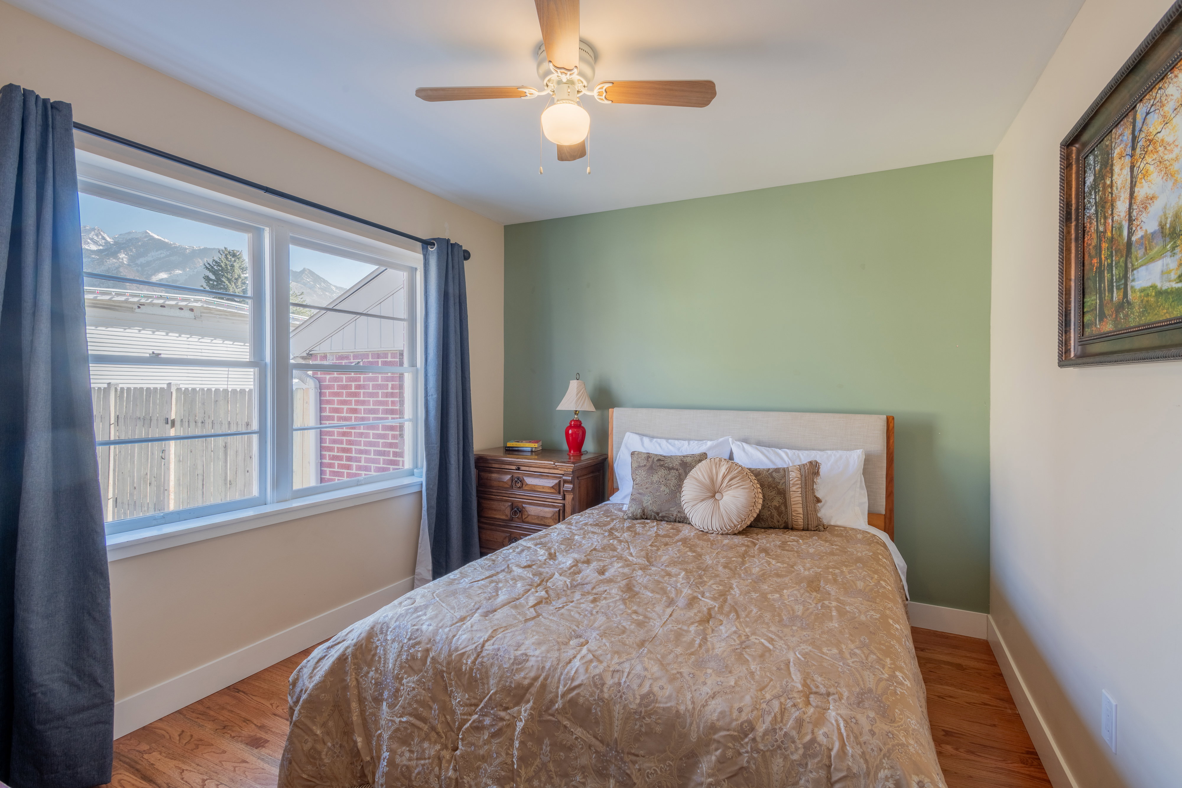 Bedroom with wood finished floors, ceiling fan, and a mountain view