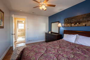 Bedroom with dark wood-type flooring and a ceiling fan