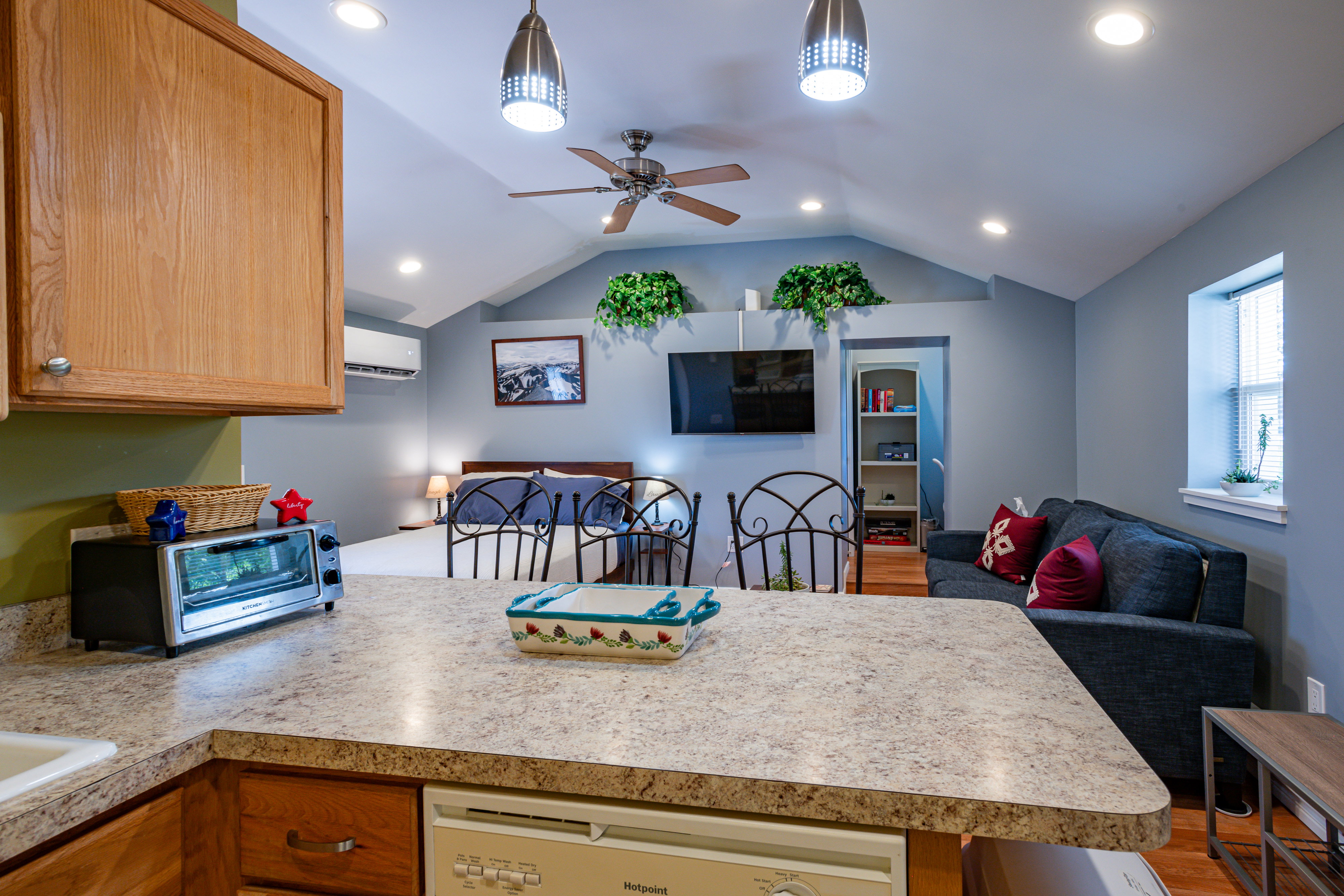 Kitchen with open floor plan, a peninsula, white dishwasher, and light countertops