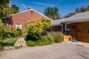 View of side of home with brick siding and a chimney