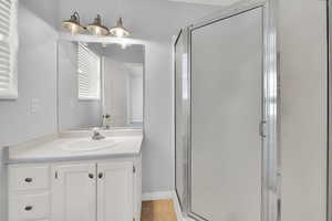 Full bathroom with a stall shower, vanity, and light tile patterned flooring