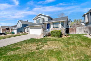 View of front of house with concrete driveway, stone siding, a garage, and a shingled roof