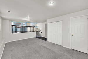 Basement featuring dark carpet and baseboards