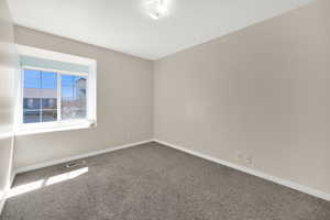 Carpeted spare room with baseboards